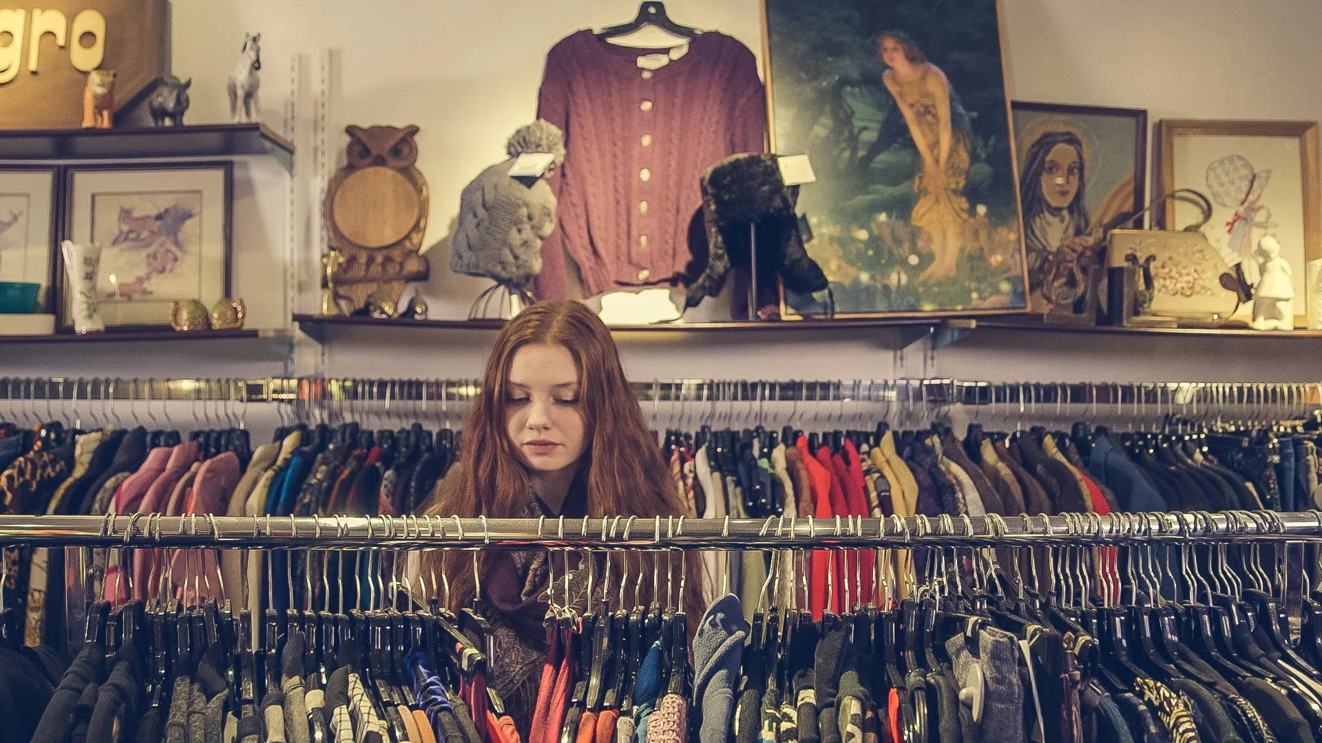 A shopper browsing rails of clothing in a vintage shop